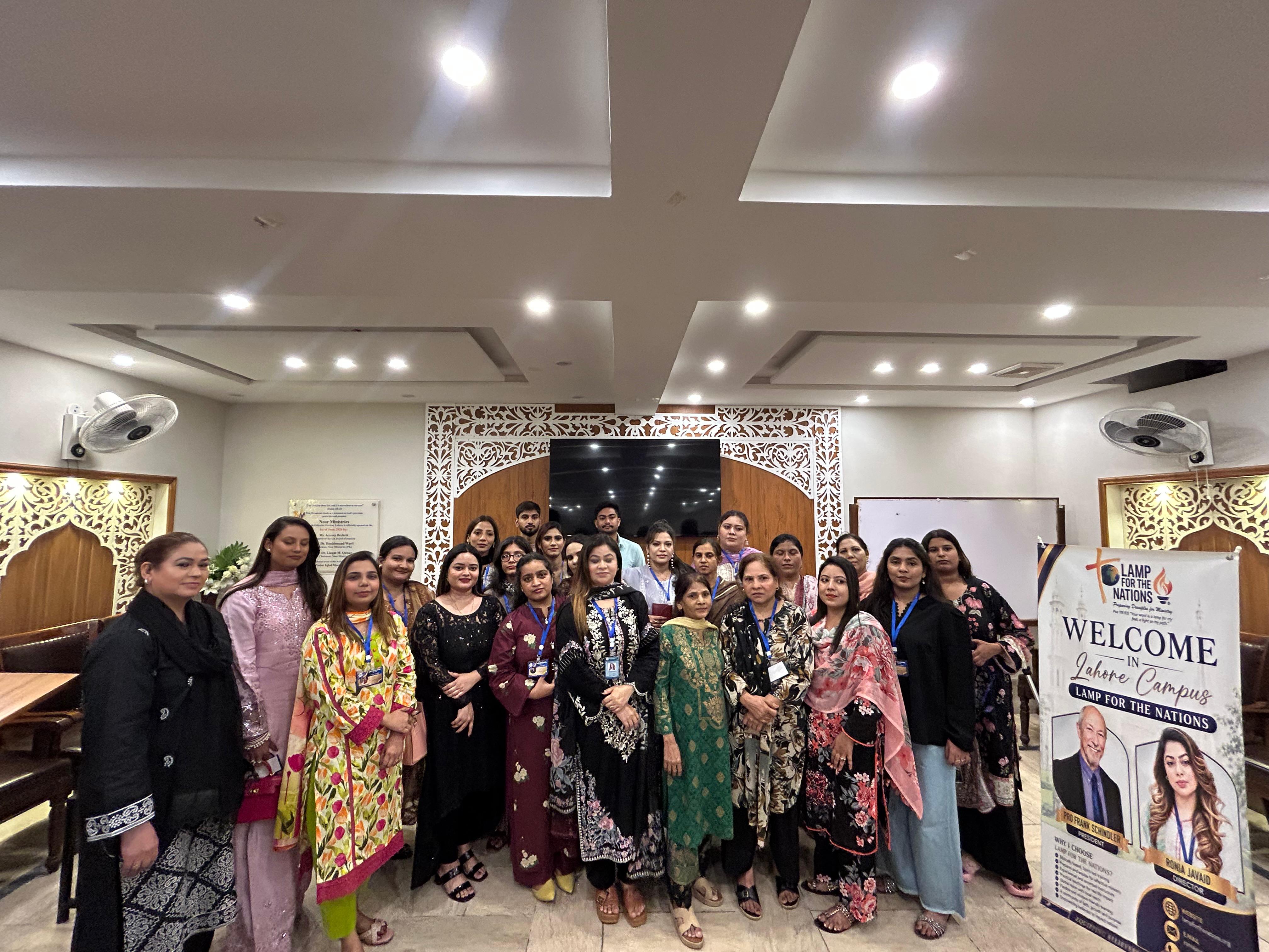 Lahore Campus students gathered in front of the Lamp For The Nations welcome banner